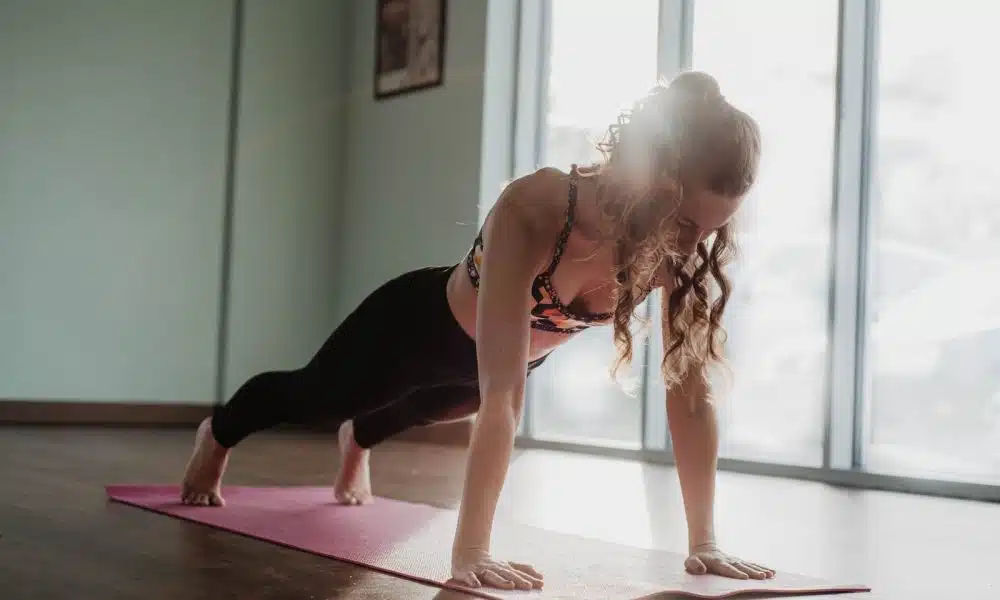 woman in black tank top and black leggings doing yoga