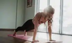 woman in black tank top and black leggings doing yoga