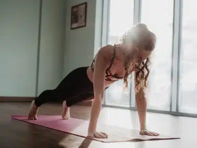woman in black tank top and black leggings doing yoga