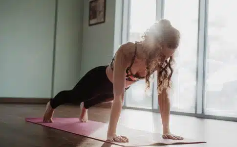 woman in black tank top and black leggings doing yoga