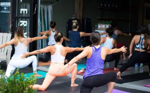 woman in white tank top and pink leggings doing yoga